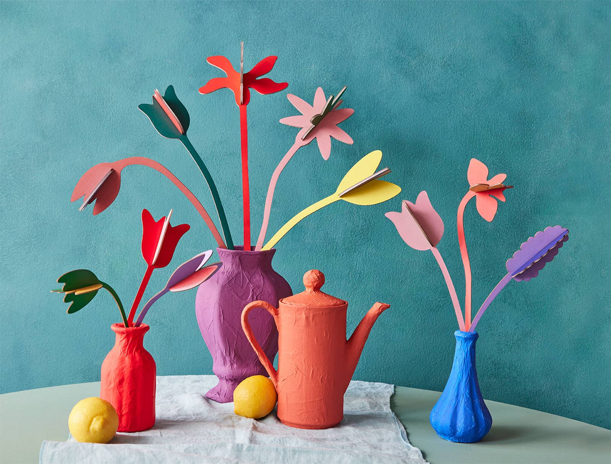 Colorful Studio ROOF cardboard flower bouquets including Tulip Love arranged in vases on a table